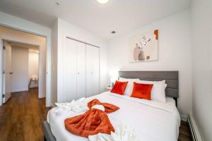 1 dormitorio con 1 cama blanca grande con almohadas de color naranja en Exotic,LUSH,Rainforest,CR,Suite,King,U/G,Wifi, en Edmonton