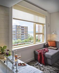 a living room with a couch and a large window at Hotel Vermont Burlington in Burlington