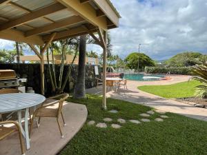 um pátio com uma mesa e cadeiras e uma piscina em Beach Villas at Kahalu'u em Kailua-Kona