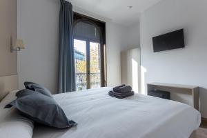 a bedroom with a large white bed with a window at Hostalin Barcelona Passeig de Gràcia in Barcelona