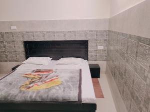 a bedroom with a large bed with a brick wall at Vidya Guest House in Katra