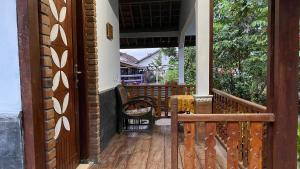 una porta aperta su un portico con tavolo e sedie di Homestay Candi Pawon Murtakim Syariah a Mendut