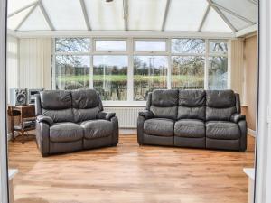 2 sillas de cuero y un sofá en la sala de estar en Holmfield, en Willoughby