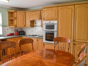 a kitchen with wooden cabinets and a wooden table with chairs at Holmfield in Willoughby