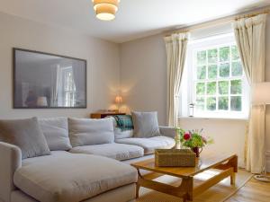 a living room with a couch and a table at Cooks Cottage in Knossington