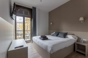 a bedroom with a large bed and a window at Hostalin Barcelona Passeig de Gracia in Barcelona