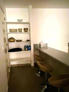 a kitchen with a counter and stools in a room at Hermoso apartamento en Ocean Reef San Bartolo, con acceso piscina y área sociales! in San Bartolo