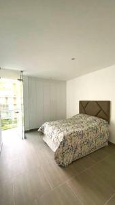 1 dormitorio con 1 cama en una habitación blanca en Hermoso apartamento en Ocean Reef San Bartolo, con acceso piscina y área sociales!, en San Bartolo