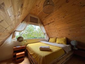 a bed in a wooden room with a window at Nấp ở TEEPEE homestay in Da Lat