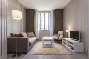 a living room with a couch and a tv at Charmants appartements centre ville in Montpellier