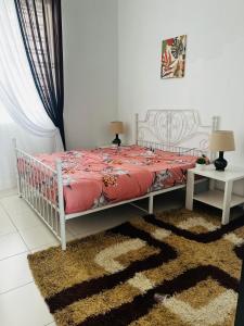a bedroom with a white bed with a red comforter at Villa Pool Kepala Batas in Kampong Hilir