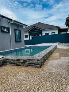 a swimming pool in front of a house at Villa Pool Kepala Batas in Kampong Hilir