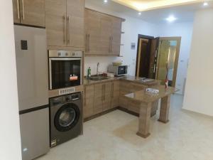 Executive Apartments في عمّان: مطبخ مع غسالة وغسالة صحون