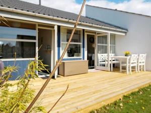 a house with a wooden deck with a table at Holiday home Væggerløse CCXIII in Bøtø By