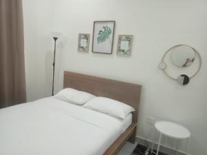 a bedroom with a bed and a mirror and a table at ZR D'Chili Homestay, Kemaman in Cukai