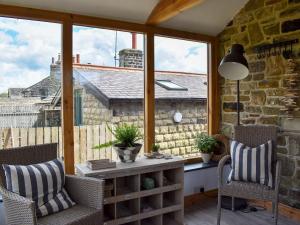 Habitación con ventana grande con sillas y mesa. en Little Plumtree, en Addingham