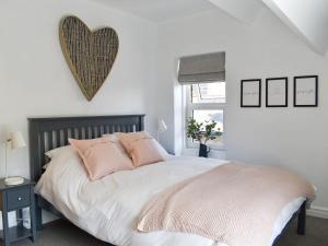 um quarto com uma cama grande e almofadas cor-de-rosa em Little Plumtree em Addingham