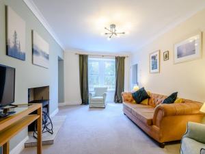 a living room with a couch and a tv at Great Whaup in Culter