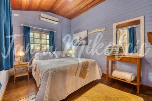 um quarto com paredes azuis, uma cama e uma mesa em Looking Good Surf House San Juan del Sur em San Juan del Sur