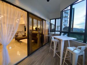 a room with large windows and a table and chairs at The View Feringghi Executive Apartment in Batu Ferringhi