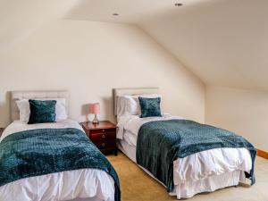 a bedroom with two beds and a night stand at The Milking Parlour in Tutbury