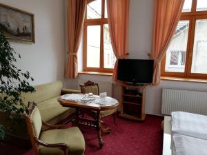 a living room with a table and a tv at Pension sv. Florian in Hlučín