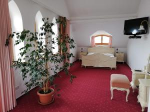 a bedroom with a bed and a potted plant at Pension sv. Florian in Hlučín