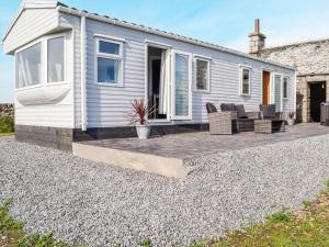 a tiny house with a patio in front of it at The Seaview Retreat - Uk35883 in Broughton Mains