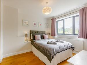 sypialnia z łóżkiem i oknem w obiekcie Stocks Cottage w mieście Blockley