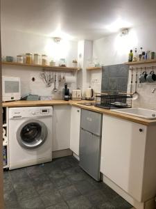 a kitchen with a washing machine and a sink at L'Aiguillerie in Montpellier