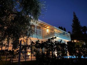 a white house with a balcony at night at Verdolivo in Sale Marasino