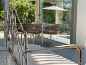 a white bench sitting on a porch with an umbrella at Verdolivo in Sale Marasino