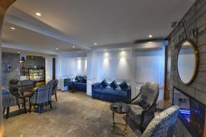 un soggiorno con divano blu e sedie di The Cedar Grand Hotel and Spa a Shimla