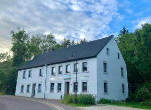 a white building with a black roof on a street at Ferienwohnung in Gersheim / bis 4 Personen in Gersheim