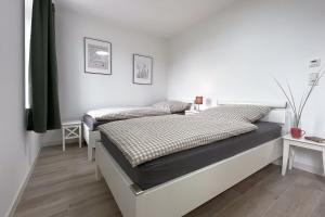 two beds in a bedroom with white walls at Gut Groß Fedderwarden, Ferienwohnung Mettje in Butjadingen
