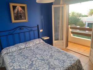 1 dormitorio con cama y pared azul en Gran casa con Bonito Jardin, en Cala'n Bosch