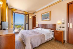 um quarto de hotel com uma cama e uma televisão em Hotel Panorama em Veneza-Lido