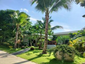 a garden with palm trees and a building at Sunset resorts and bar in Ban Nong Chaeng