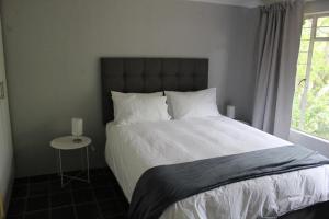 um quarto com uma cama grande e uma janela em Self-Catered Apartment With Pool em Krugersdorp