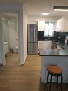 kuchnia z lodówką, blatem i stołkiem w obiekcie Newly Renovated Varkiza Beachside One Bedroom with Large Terrace w Atenach +8 zdjęć