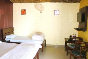 a room with three beds and a table and a clock at Windsor Cottages in Lansdowne