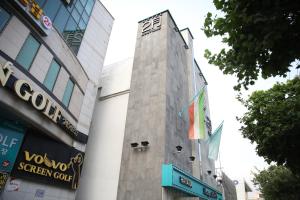 a building with a flag on the side of it at Daegu February Hotel Suseong in Daegu