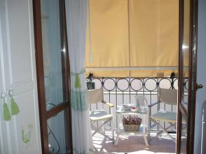 einen Balkon mit 2 Stühlen und einem Tisch auf dem Balkon in der Unterkunft Le Pavoncelle in Alghero