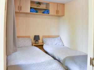 two beds in a room with a table and cabinets at The Reme Villa in Scorton