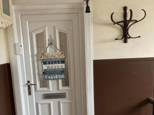 białe drzwi z napisem w obiekcie Coastal Views Millport w mieście Millport