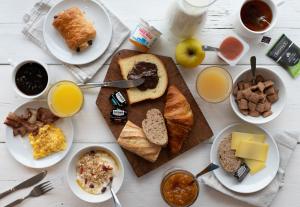 - une table avec des assiettes de produits pour le petit-déjeuner et des boissons dans l'établissement B&B HOTEL Sète Centre Gare, à Sète
