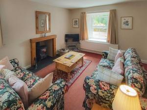 un soggiorno con 2 divani e un tavolo di Uk35716 - North Cottage a Teviothead