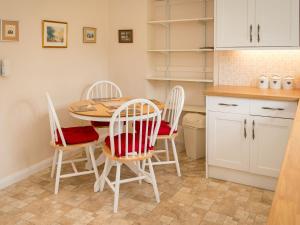 una cucina con tavolo e 4 sedie di Uk35716 - North Cottage a Teviothead