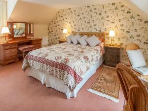 una camera con un grande letto e uno specchio di Uk35716 - North Cottage a Teviothead