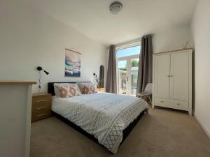 a bedroom with a bed and a large window at Seafield Lodge in Grantown on Spey